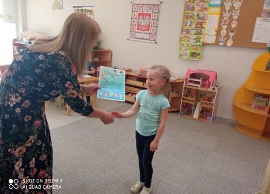 Pani dyrektor wręcza nagrodę Poli Okrój za zajęcie I miejsca w kategorii 5-latków. grafika